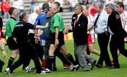 19 June 2005; Referee Gerry Kinneavy leaves the field while being confronted by Tyrone players and officials. Bank of Ireland Ulster Senior Football Championship Semi-Final, Tyrone v Cavan, St. Tighernach's Park, Clones, Co. Monaghan. Picture credit; Oliver McVeigh / SPORTSFILE