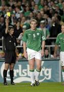 12 October 2005; Richard Dunne, Republic of Ireland, is shown the yellow card by referee Markus Merk. FIFA 2006 World Cup Qualifier, Group 4, Republic of Ireland v Switzerland, Lansdowne Road, Dublin. Picture credit: Brian Lawless / SPORTSFILE