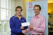 17 July 2006; Scott Evans, the 18 year-old Dublin badminton star, has been awarded a Beijing Olympic Scholarship by the Olympic Council of Ireland. Scott is Ireland's highest ranked badminton player with a current world ranking of 76. He intends using the scholarship to continue training full-time in Denmark with the objective of reaching a top 50 ranking in the coming year - a position that would gain him Olympic qualification. Scott hails from Dundrum and plays with the Ailesbury Badminton Club based in Terenure College, Dublin. He is also a full-time professional in the Danish Premier Badminton League and will represent Ireland in the World Championships in Spain in September. Stephen Martin, right, presents the Beijing Olympic Scholarship to Scott prior to Scott's departure to Denmark for renewed coaching and training. For further information contact Scott Evans at 087-1311353 or the OCI Press Officer Jack McGouran at 086-8562649. Olympic Council of Ireland Head Office, Howth, Co. Dublin. Picture credit: Brendan Moran / SPORTSFILE