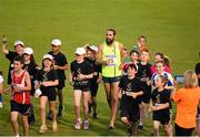 11 July 2014; Will Leer, U.S.A, runs a parade lap with children after winning The Morton Mile. 2014 Morton Games, Morton Stadium, Santry, Co. Dublin. Picture credit: Ramsey Cardy / SPORTSFILE