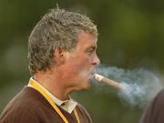 22 September 2006; Darren Clarke, Team Europe 2006, smokes a cigar while watching Friday afternoon's foursomes matches. 36th Ryder Cup Matches, K Club, Straffan, Co. Kildare, Ireland. Picture credit: Matt Browne / SPORTSFILE
