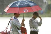 22 September 2006; Tiger Woods, Team USA 2006, and his caddy Steve Williams, shelter from the rain on the 18th green during Friday afternoon's four-somes matches. 36th Ryder Cup Matches, K Club, Straffan, Co. Kildare, Ireland. Picture credit: Brendan Moran / SPORTSFILE