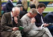 24 April 2007; Racegoers study the form at the Punchestown National Hunt Festival. Punchestown Racecourse, Co. Kildare. Picture credit: David Maher / SPORTSFILE