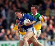 23 April 2000; Philip Smith of Cavan is tackled by John Ryan of Offaly during the Church & General National Football League Division 2 Semi-Final match between Offaly and Cavan at Cusack Park in Mullingar, Westmeath.  Photo by Aoife Rice/Sportsfile
