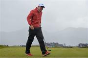 28 May 2015; Rory McIlroy, Northern Ireland, on his way to take shelter from a heavy shower. Dubai Duty Free Irish Open Golf Championship 2015, Day 1. Royal County Down Golf Club, Co. Down. Picture credit: Ramsey Cardy / SPORTSFILE