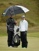29 May 2015; Rory McIlroy, Northern Ireland, and his caddy JP Fitzgerald, shelter from the rain on the 9th fairway. Dubai Duty Free Irish Open Golf Championship 2015, Day 2. Royal County Down Golf Club, Co. Down. Picture credit: Brendan Moran / SPORTSFILE