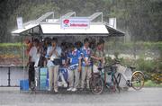 10  August 2008; Rainy day in Beijing. Cyclists and volunteers take shelter during a very heavy shower of rain MPC, Beijing 2008 - Games of the XXIX Olympiad, Beijing, China. Picture credit: Ray McManus / SPORTSFILE