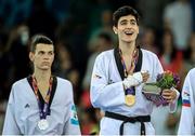 17 June 2015; Aykhan Taghizade, Azerbaijan, sings the National Anthem after receiving the Men's Taekwondo 68kg Gold Medal as silver medallist Robak Karol, Poland, watches on. 2015 European Games, Crystal Hall, Baku, Azerbaijan. Picture credit: Stephen McCarthy / SPORTSFILE