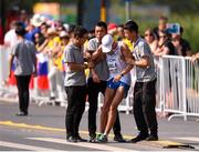 29 August 2015; Aleksi Ojala of Finland is assisted after collapsing during the Men's 50km Race Walk final. IAAF World Athletics Championships Beijing 2015 - Day 8, National Stadium, Beijing, China. Picture credit: Stephen McCarthy / SPORTSFILE