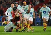 11 December 2009; Alan Quinlan, Munster, is tackled by Yannick Parent, left, and Bertrand Guiry, Perpignan. Heineken Cup Pool 1 Round 3, Munster v Perpignan, Thomond Park, Limerick. Picture credit: Diarmuid Greene / SPORTSFILE