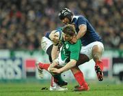 13 February 2010; Brian O'Driscoll, Ireland, is tackled by Imanol Harinordoquy, left, and theirry Dusautoir. RBS Six Nations Rugby Championship, France v Ireland, Stade de France, Saint Denis, Paris, France. Picture credit: Brendan Moran / SPORTSFILE