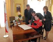 14 April 2010; Special Olympics athlete Dermot Leavy, in the company of Polish Ambassador to Ireland Dr. Tadeusz Szumowski, Matt English, CEO, Special Olympics Ireland and Mary Davis, Managing Director, Special Olympics Europe / Eurasia, signs a book of condolence at the Polish Embassy in Dublin in memory of Polish President Mr. Lech Kaczynski, First Lady Mrs Maria Kaczynska and 95 others who died in a plane crash in Russia last Saturday. Mr & Mrs Kaczynska were strong supporters of the Special Olympics movement and were involved in Poland’s preparation to host the 2010 European Games in September. Afterwards the Special Olympics delegation met with the Ambassador to convey, on behalf of the Special Olympics movement in Europe, their deepest condolences to the people of Poland. Embassy of the Republic of Poland, Ballsbridge, Dublin. Picture credit: Brendan Moran / SPORTSFILE