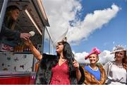 29 April 2016; Ailbhe McMonagle, from Falcarragh, Co. Donegal, buys an ice cream cone from Catherine Noland, from Tallaght, Co. Dublin, alongside friends, Anna Carthy, right, from Rathfarnam, Co. Dublin, and Rebecca Haughan, from Newcastle, Co. Dublin, ahead of the races. Punchestown, Co. Kildare. Picture credit: Cody Glenn / SPORTSFILE