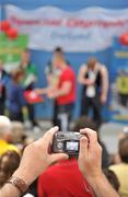 12 June 2010; A spectator takes a picture during the Gymnastics medal presentation during the third day of the 2010 Special Olympics Ireland Games. University of Limerick, Limerick. Picture credit: Stephen McCarthy / SPORTSFILE