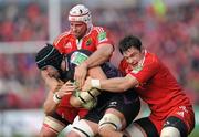 12 December 2010; Jonathan Thomas, Ospreys, is tackled by Denis Leamy, left, and David Wallace, Munster. Heineken Cup Pool 3 - Round 3, Munster v Ospreys, Thomond Park, Limerick. Picture credit: Matt Browne / SPORTSFILE