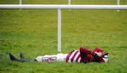 30 December 2010; Jockey Robert Ppower lies on the ground after being unseated by his mount Saludos at the last, while leading, during the The Bord na Mona With Nature Novice Steeplechase. Leopardstown Christmas Racing Festival 2010, Leopardstown Racecourse, Leopardstown, Dublin. Picture credit: Stephen McCarthy / SPORTSFILE