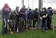 2 February 2011; Dublin City University substitutes take shelter behind each other during a heavy shower at half-time. Ulster Bank Fitzgibbon Cup, Group 2, Dublin City University v University of Limerick, O'Toole's GAA Club, Pairc Uí Thuathail, Blunden Drive, Dublin. Picture credit: Brian Lawless / SPORTSFILE