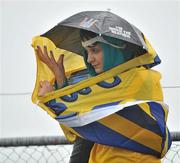 17 July 2011; Roscommon supporter Mary McEvoy, from Roscommon town, Co. Roscommon, shelters from the heavy rain at the Connacht GAA Football Senior Championship Final, Dr. Hyde Park, Roscommon. Picture credit: David Maher / SPORTSFILE