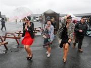 25 April 2012; Racegoers, from left, Sarah O'Neill, Aisling Kilduff and Amy McGreal, from Kilcock, Co. Kildare, arrive during heavy rain for the second day of the Punchestown Racing Festival. Punchestown Racecourse, Punchestown, Co. Kildare. Picture credit: Stephen McCarthy / SPORTSFILE
