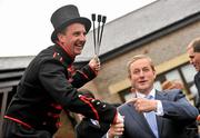 26 April 2012; An Taoiseach Enda Kenny T.D. is greeted by fire breather William Corvenieos as he arrives for the third day of the Punchestown Racing Festival. Punchestown Racing Festival, Punchestown Racecourse, Punchestown, Co. Kildare. Picture credit: Barry Cregg / SPORTSFILE