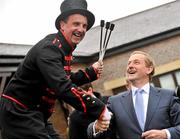 26 April 2012; An Taoiseach Enda Kenny T.D. is greeted by fire breather William Corvenieos as he arrives for the third day of the Punchestown Racing Festival. Punchestown Racing Festival, Punchestown Racecourse, Punchestown, Co. Kildare. Picture credit: Barry Cregg / SPORTSFILE