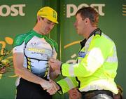 26 May 2012; Brian Ahern, Dublin Dundrum Town Centre, is presented with his Cuchulainn Crystal best place county rider award by Garda Sgt Brendan Hoare following the seventh stage of the 2012 An Post Rás. Donegal - Cootehill. Picture credit: Stephen McCarthy / SPORTSFILE