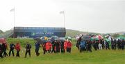 28 June 2012; Spectators leave the course after a severe weather warning was issued, resulting in play being suspended. 2012 Irish Open Golf Championship. Royal Portrush, Portrush, Co. Antrim. Picture credit: Oliver McVeigh / SPORTSFILE