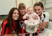 8 October 2012; Cork's Orlagh Farmer, left, Emma Farmer and Annie Walsh with Lola Parkinson, aged 3 months, from Cabra, Co. Dublin, in the Brendan Martin Cup during a visit to Temple Street Children's Hospital, Temple Street, Dublin. Photo by Sportsfile