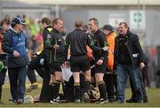 7 April 2013; Replacement referee Michael Duffy , centre, speaks to TJ Keavey, sideline official, left, and Brendan Rice, right, as the injured Referee Padraig Hughes lies on the ground in the second half. Allianz Football League, Division 1, Donegal v Dublin, Páirc MacCumhaill, Ballybofey, Co. Donegal. Picture credit: Oliver McVeigh / SPORTSFILE